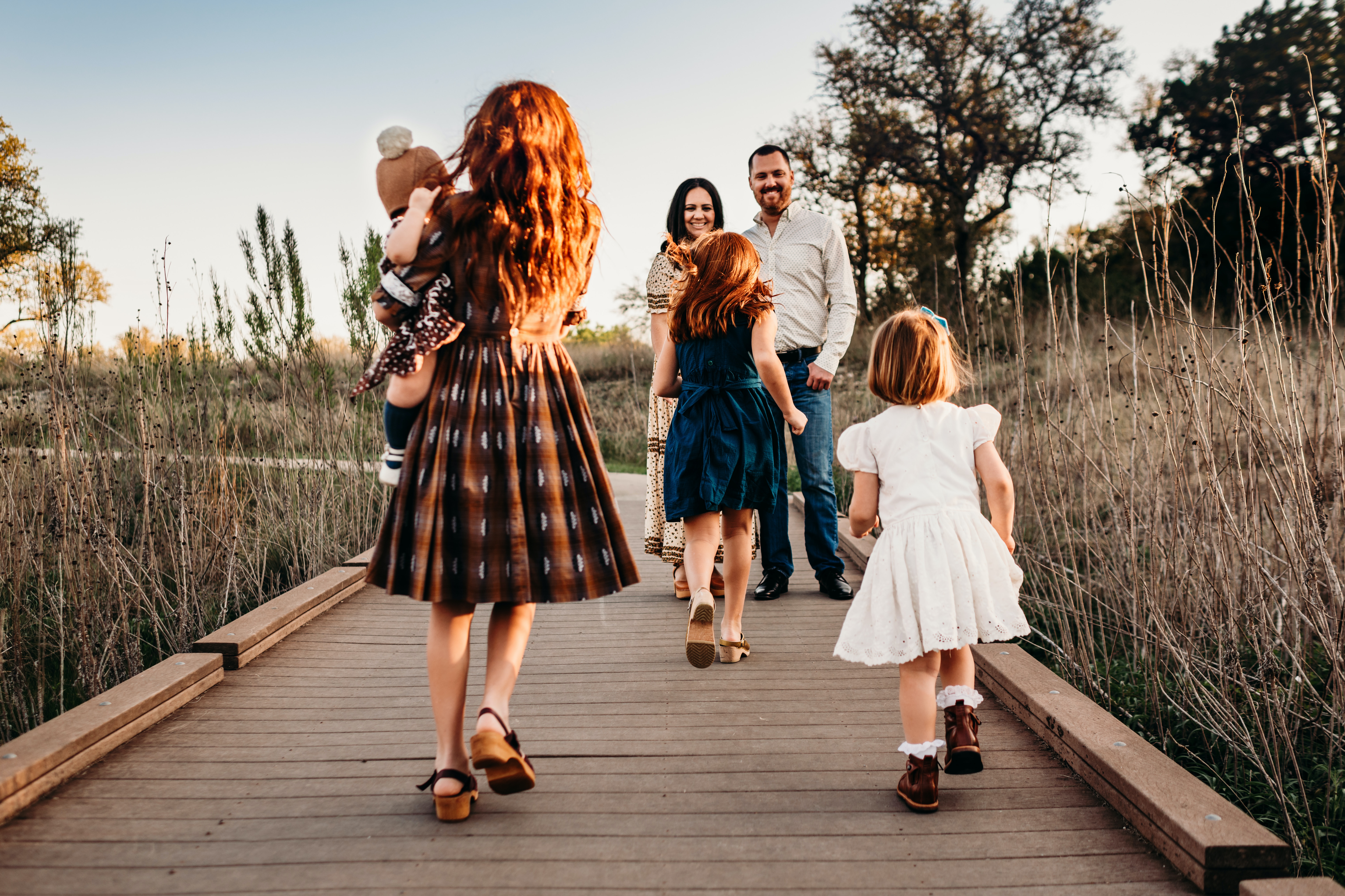 Parents and kids on bridge in family portrait.