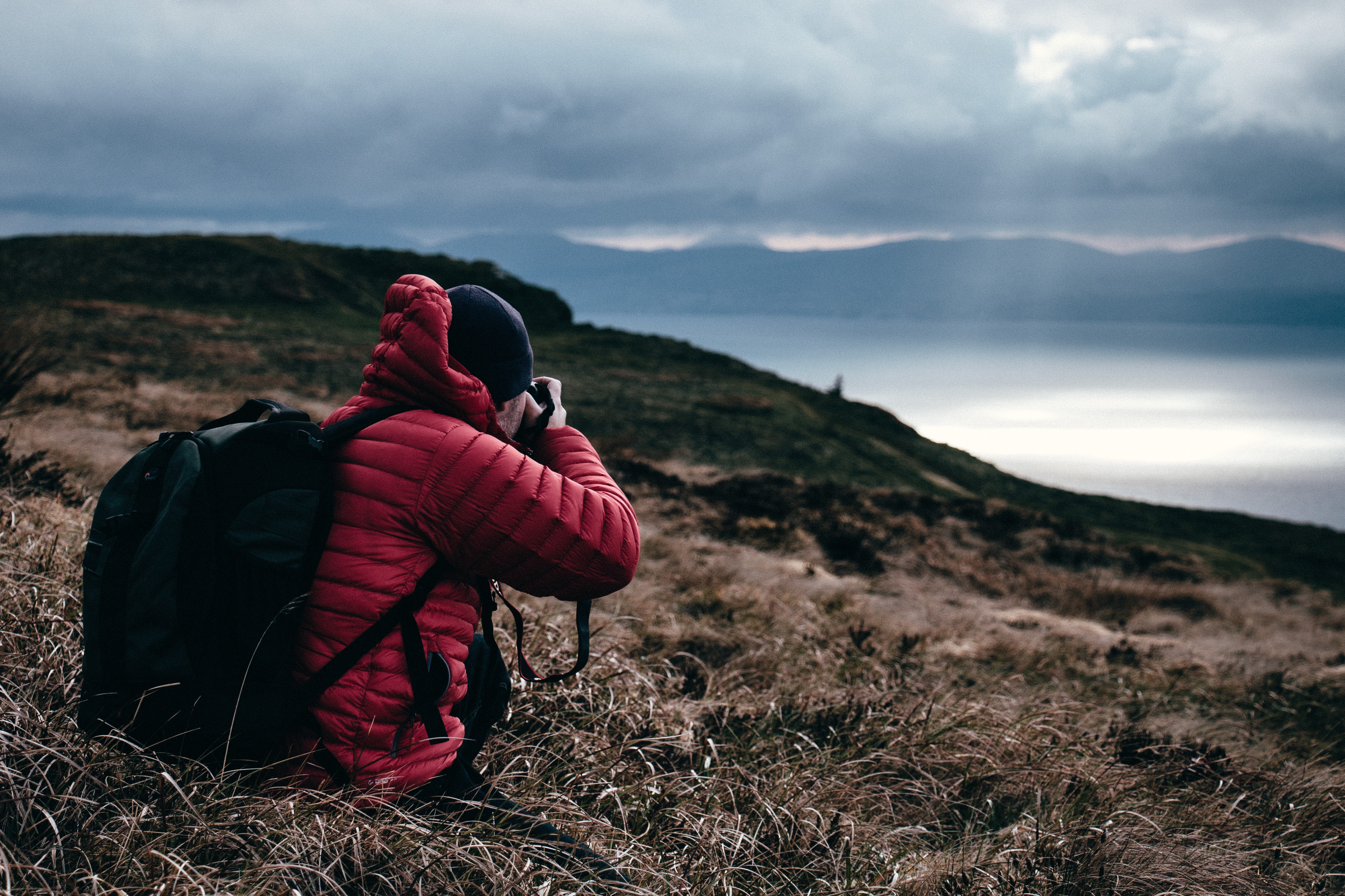 Travel photographer on mountain taking picture of ocean